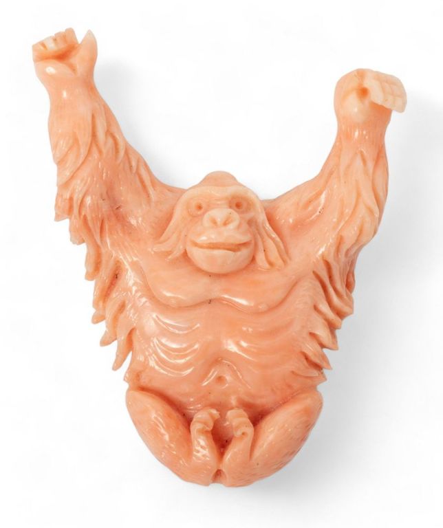 Carved coral ape brooch