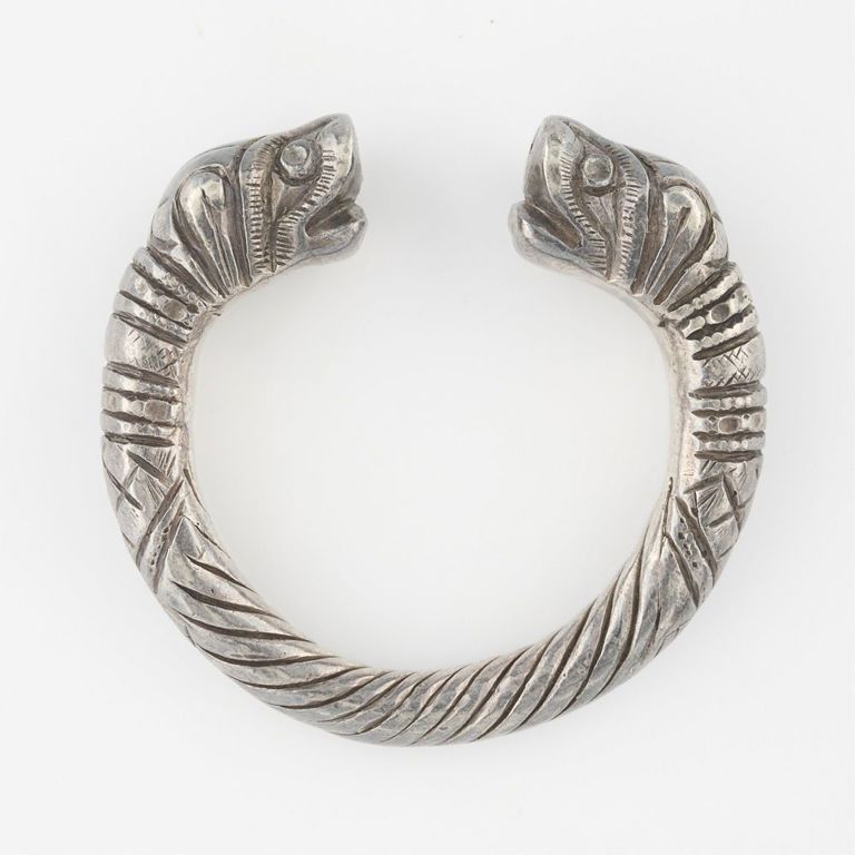 Weighted silver bangle with Makara heads
