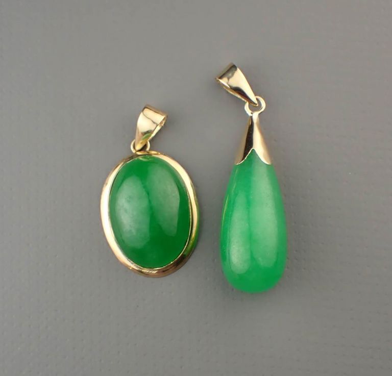 Two green jade and 14k gold pendants