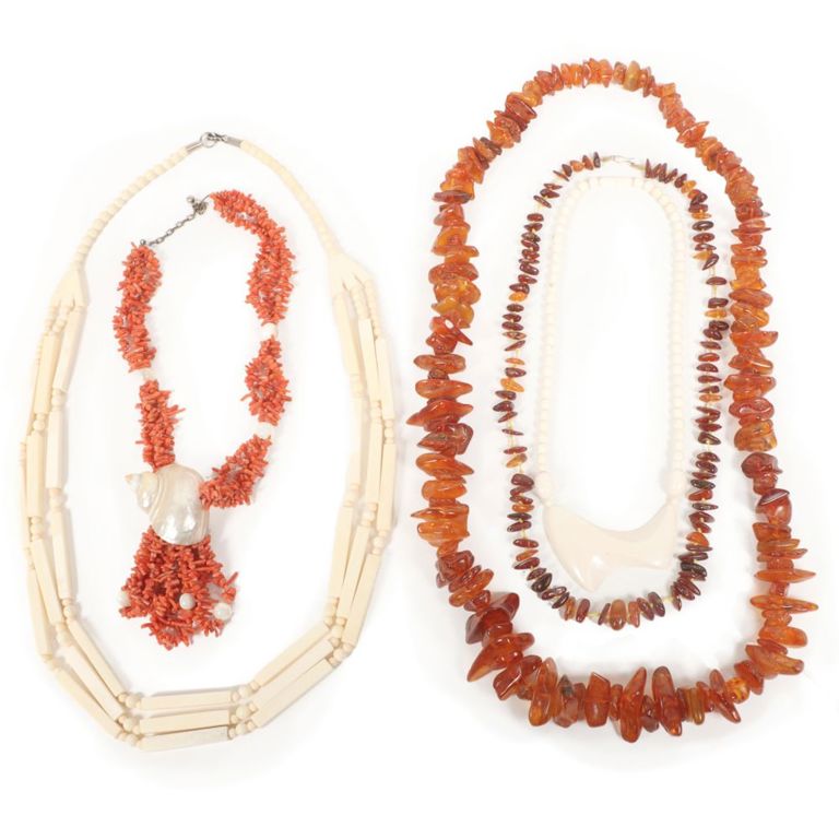 Two amber necklaces, two bone necklaces and coral necklace with seashell pendant