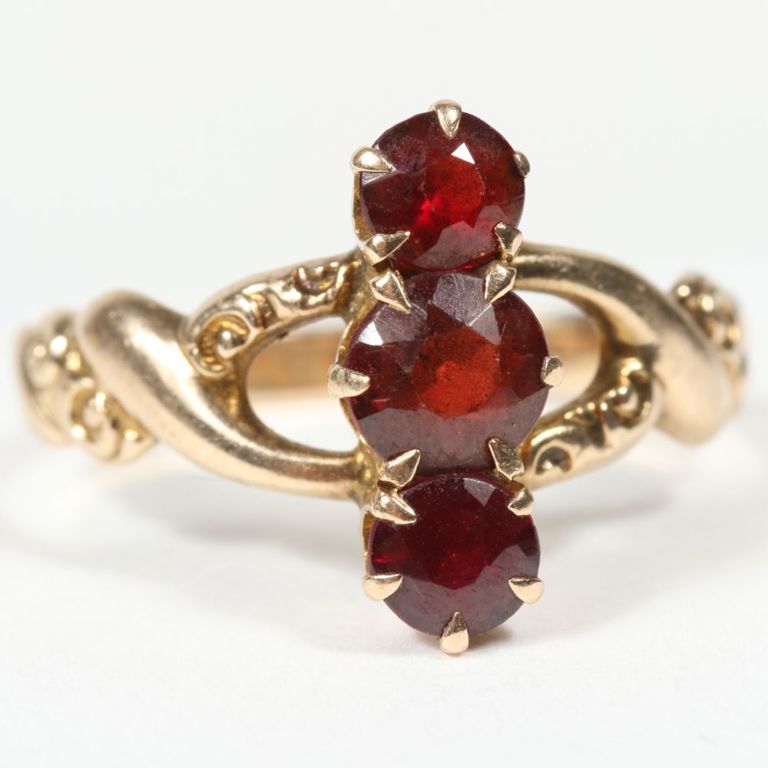 Yellow gold ring with three prong set faceted garnet