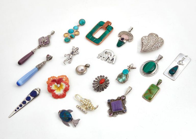 Collection of nineteen silver, metal, and hardstone brooches and pendants