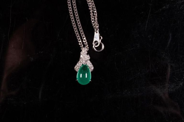 Platinum emerald and diamond pendant on necklace