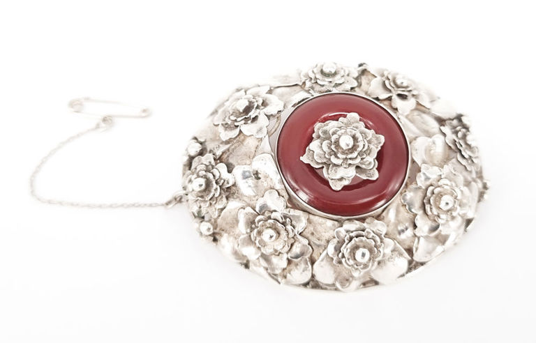 Silver and carnelian brooch with relief floral design