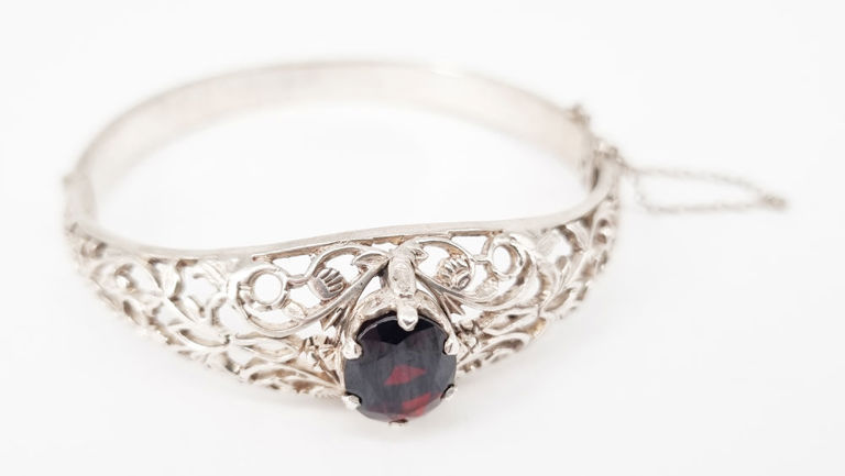 Silver hinged bangle with oval cut garnet