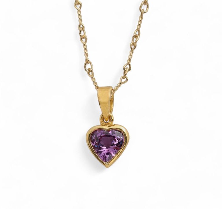 A purple sapphire and 18k gold pendant on chain
