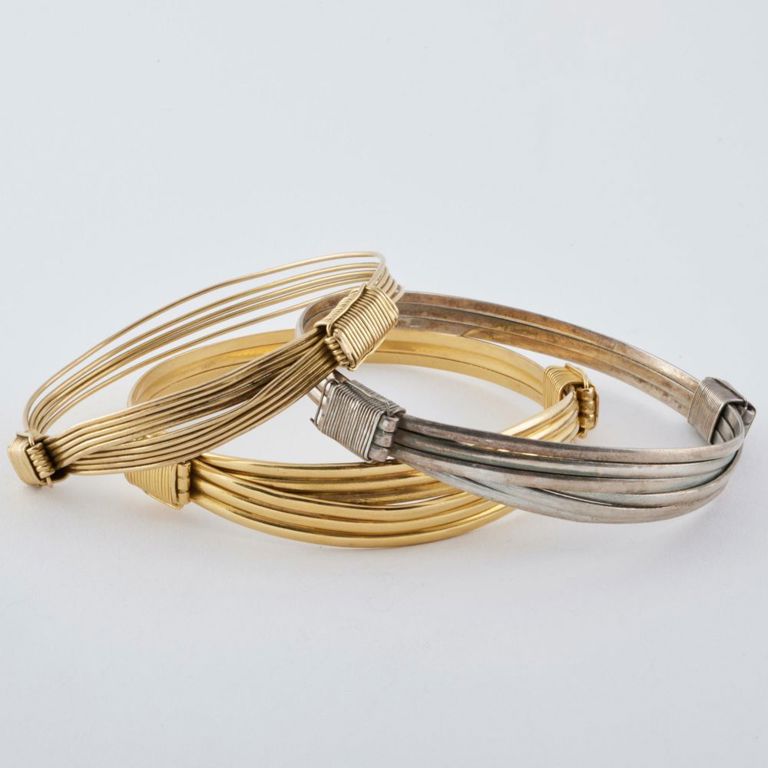 Two 14k gold adjustable bracelets and a steel adjustable bracelet