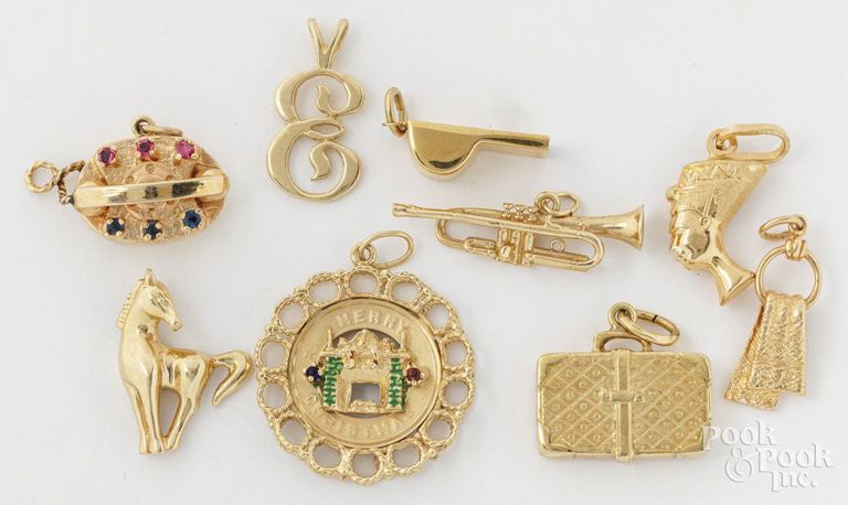 Nine 14k yellow gold charm pendants